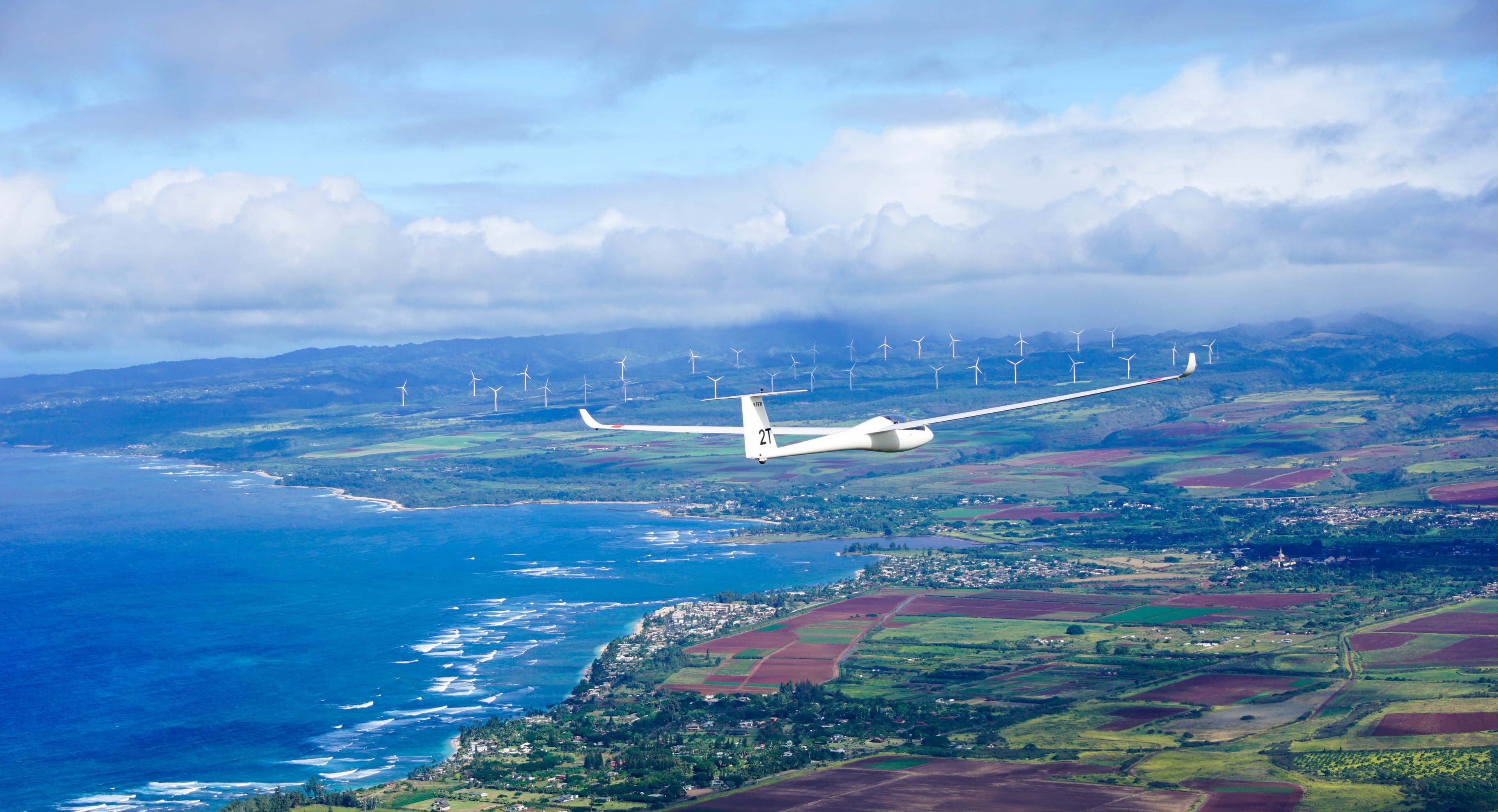 Glider riding ridge lift above the Kahuku wind turbines.